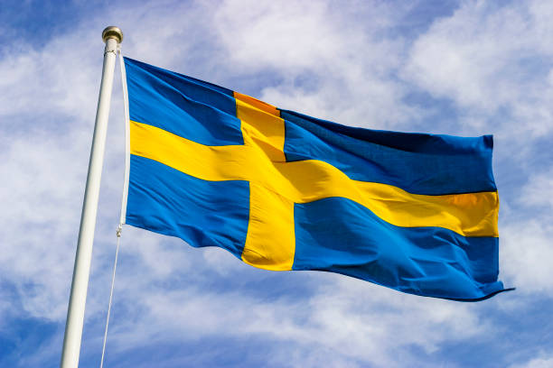 swedish flag waving in the wind in the sky - suécia imagens e fotografias de stock
