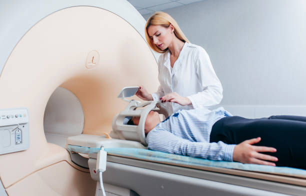 istock Radiologic model technician help at mature female patient lying on a CT Scan bed and looking at the camera 1319204314