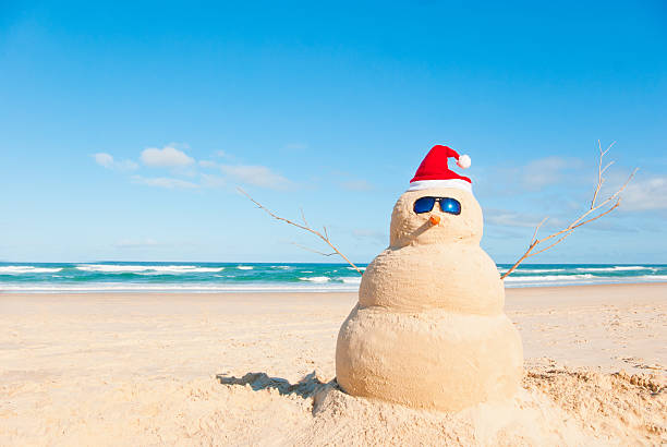 Perfect Sandman With Carrot Nose And Sunnies Snowman at the beach with sun glasses. The shells for mouth and buttons have been removed in this shot australian culture stock pictures, royalty-free photos & images