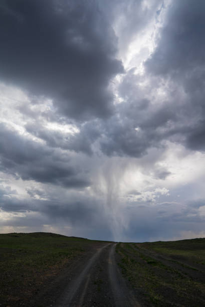 tornado in a stormy sky over a dirt road in Mongolia, vertical placement. High quality photo