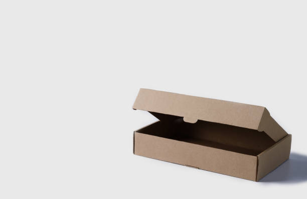 istock Open box made of brown cardboard on a light background. Empty box for packaging and delivery of goods low with copy space 1319206433