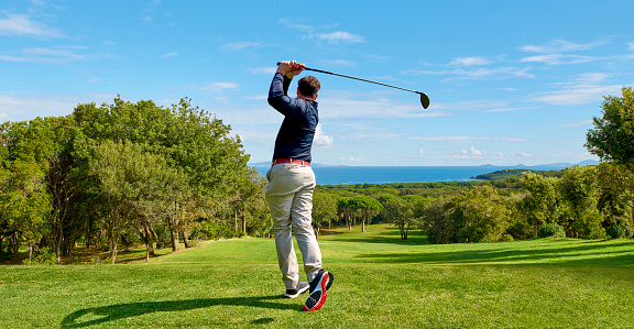Golfista en el campo de golf profesional. Golfista con palo de golf golpeando la pelota para el tiro perfecto. photo