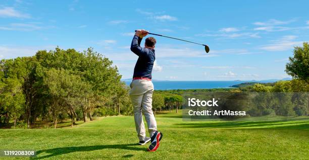 Golfer On The Professional Golf Course Golfer With Golf Club Hitting The Ball For The Perfect Shot Stock Photo - Download Image Now