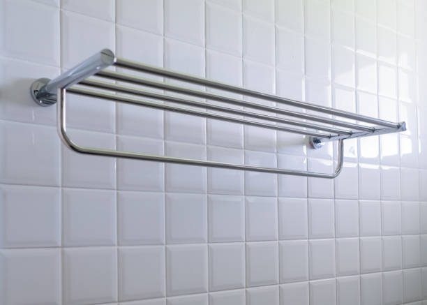 Stainless steel towel rail mounted on the white tile wall in a luxurious bathroom. stock photo