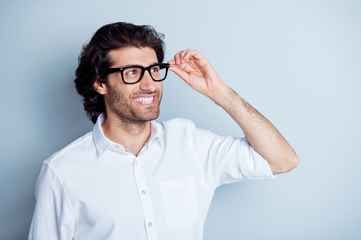 Photo portrait of dreamy man looking far holding glasses in hand isolated on clear white colored background