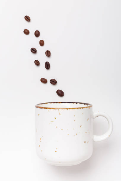 istock Ceramic mug and coffee beans on white background. Coffee break concept. Top view. Copy space 1319213622