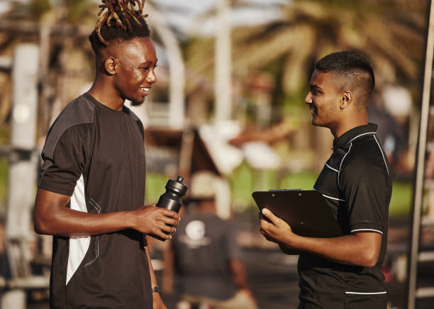 istock Shot of a young man planning his workout routine with his personal trainer 1319216827