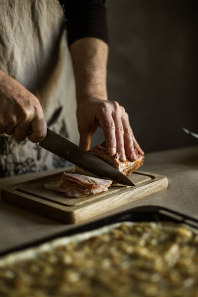 istock Male hands slicing smoked bacon on wooden board 1319221224