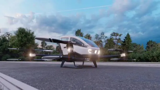 In the early morning, a high-tech air taxi departs for its destination. View of an unmanned aerial passenger vehicle standing on the road.