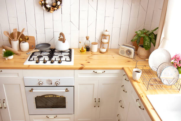 istock White kitchen interior with a plant on a wooden countertop. New modern kitchen interior 1319223810