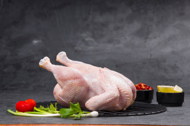 Raw whole chicken with skin stock photo