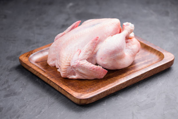 Raw whole chicken with skin stock photo