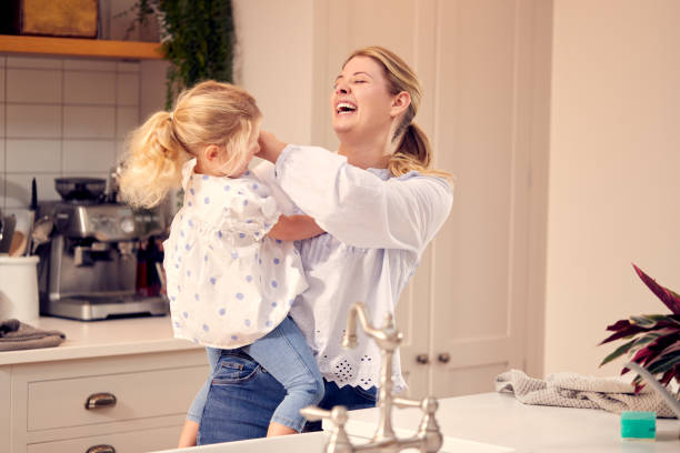 istock Mother And Daughter Having Fun In Kitchen Doing Washing Up At Sink Together 1319228143