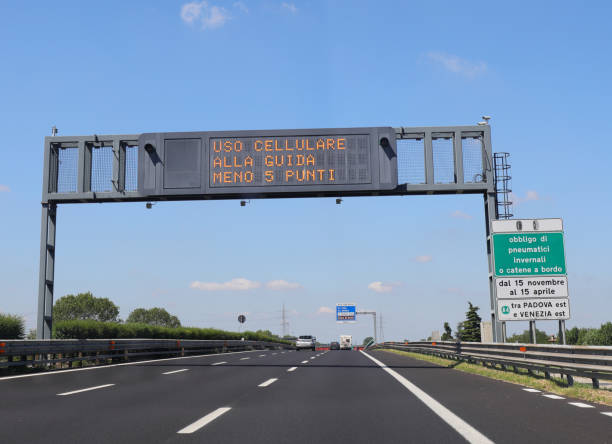istock highway sign indicating the prohibition to use the mobile phone while driving is a sign that says to always have snow chains on board the car in Italian language 1319228334