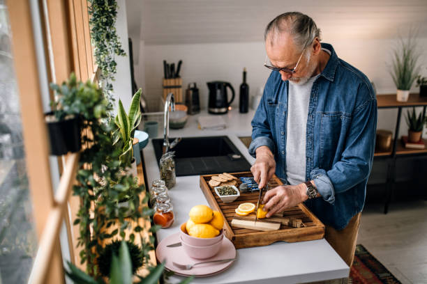 istock Senior man slicing lemon for a tea 1319230170