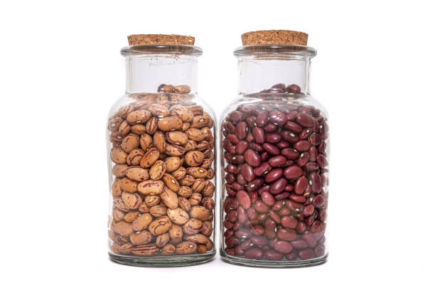 Borlotti Beans And Kidney Bean dried and preserved in glass jars isolated on a white background. Healthy nutritional preserved ingredients.