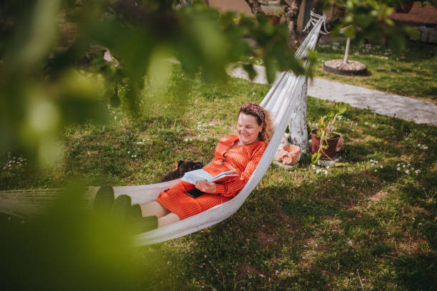 istock Young Woman Reading Book On Swing 1319231250