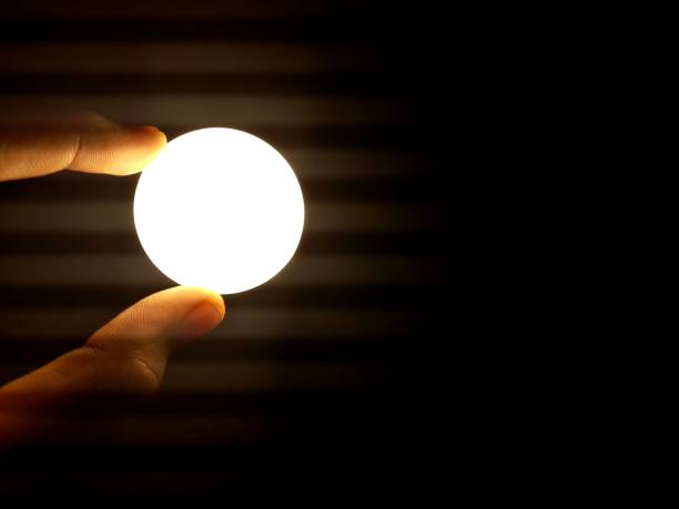 istock finger holding the lamp that resembles the moon 1319232270
