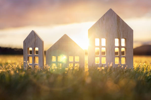 istock Ecological wood  model house in empty field at sunset 1319232495