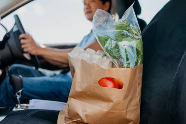Asian male driver delivering groceries to customer