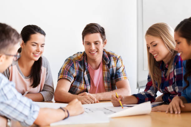 istock group of smiling students with blueprint 1319233295
