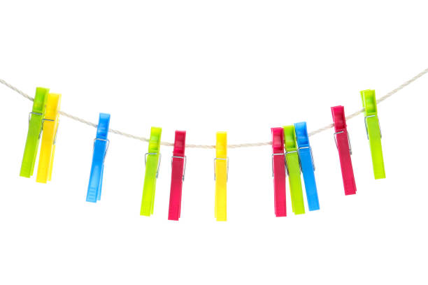 istock Colorful plastic clothespins hanging on rope against white background 1319233325