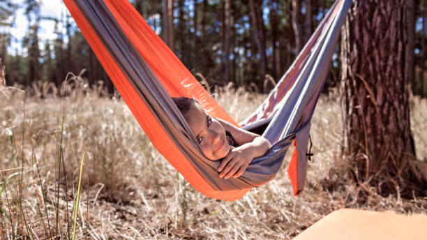 istock Girl having rest in hammock in wild forest during local vacation, unity with nature, digital detox 1319235968