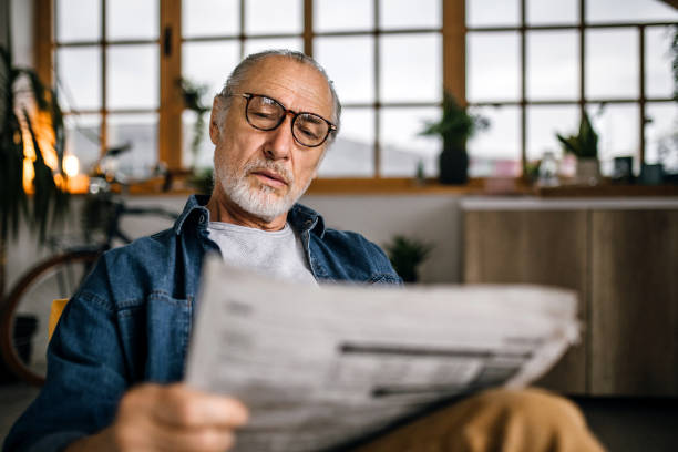 istock Senior man at home reading newspapers 1319241133