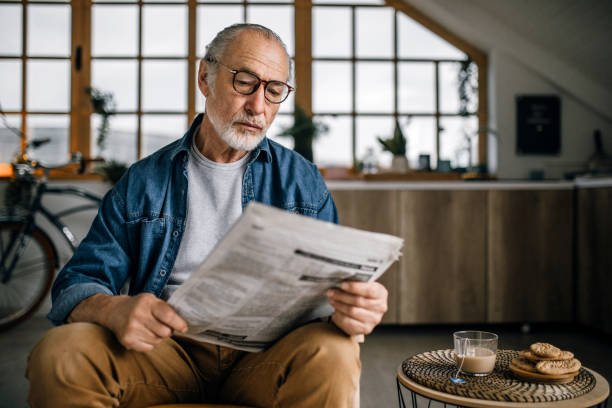 istock Senior man at home reading newspapers 1319241135