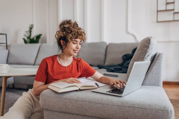istock Young woman studying in living room 1319244425