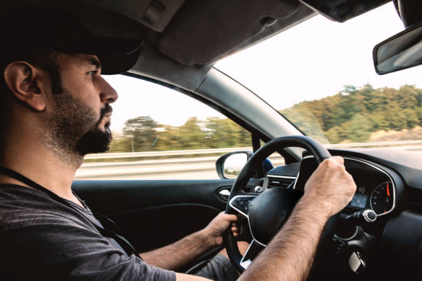 istock Side view of man driving car 1319249549