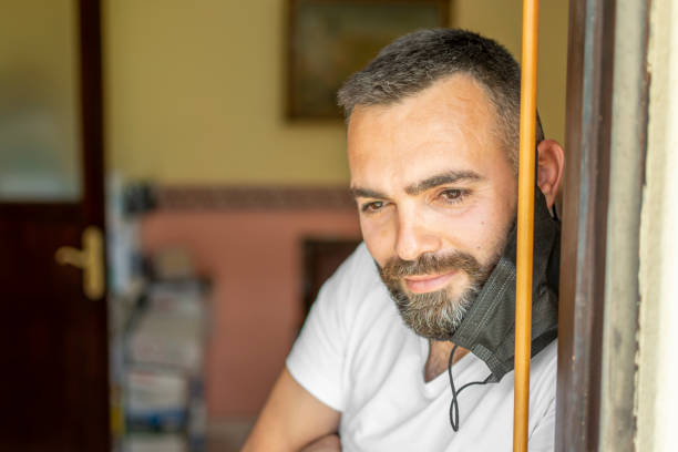 istock Handsome looking from door to quarantine with mask 1319249656