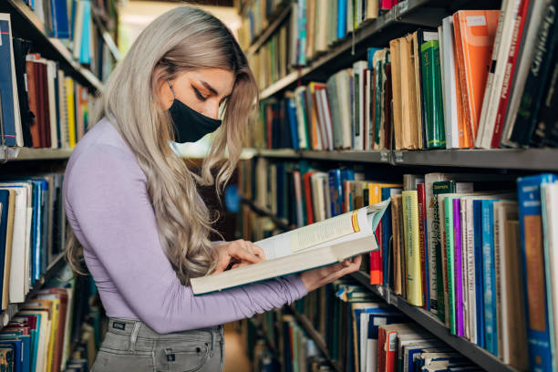 istock Female University student checking that she got a right author of textbook she need to prepare an exam 1319250610