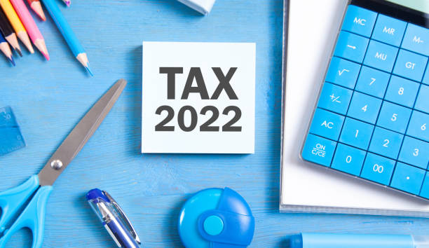 istock Tax 2022 on sticky note with a business objects. 1319250745