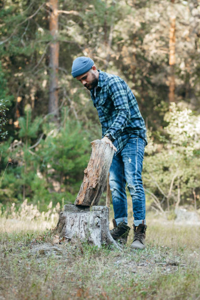 istock Stylish bearded forester chopping wood with an axe 1319253286
