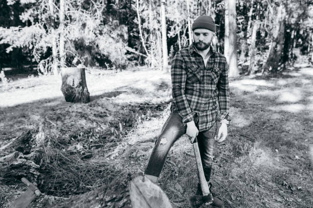 istock Stylish bearded forester chopping wood with an axe 1319253526