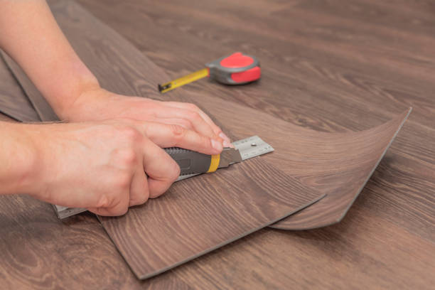 istock DIY vinyl flooring. Easy installation and cutting with a knife, Master cuts vinyl plank before installation, brown heated floor. Copy space 1319254236