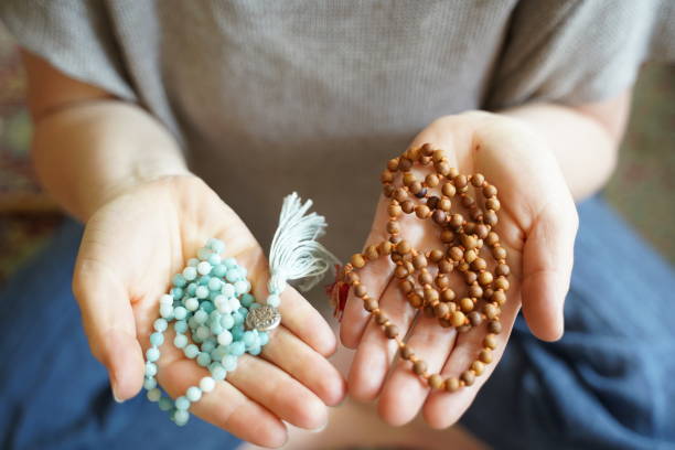Woman with mala beads in both of her hands stock photo
