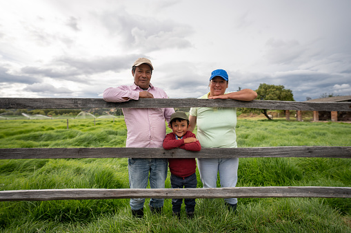 Happy Latin American family at their farm and looking at the camera smiling âlifestyle in developing countries concepts