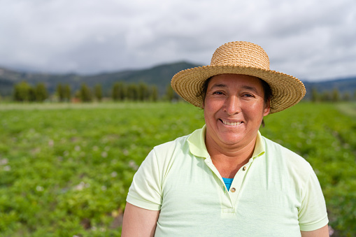 Portrait of a Latin American woman working in agriculture at a rural farm and looking at the camera smiling