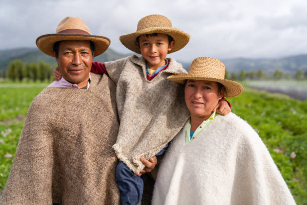 Latin American family working in agriculture at a farm and Latin American family working in agriculture at a farm and looking at the camera smiling while wearing ruanas â lifestyle concepts boyacá department photos stock pictures, royalty-free photos & images