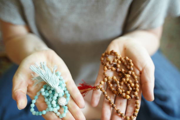 istock Woman with mala beads in both of her hands 1319254877