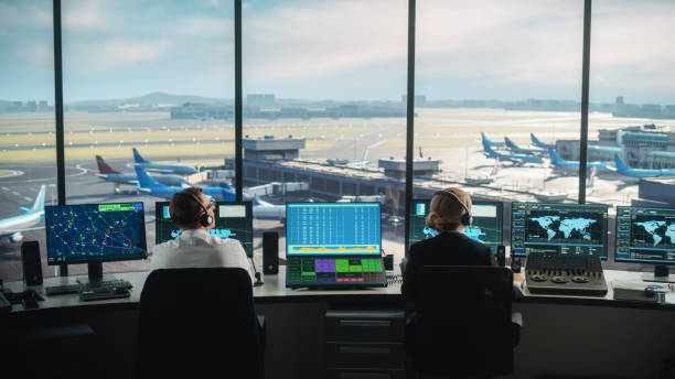 diverse air traffic control team working in a modern airport tower. office room is full of desktop computer displays with navigation screens, airplane departure and arrival data for controllers. - air vehicle audio imagens e fotografias de stock