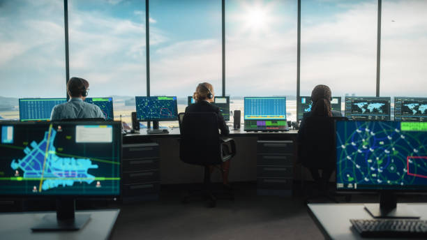 diversi team di controllo del traffico aereo che lavorano in una moderna torre aeroportuale. office room è piena di display di computer desktop con schermi di navigazione, dati radar di volo aereo per controller. - air traffic control tower foto e immagini stock