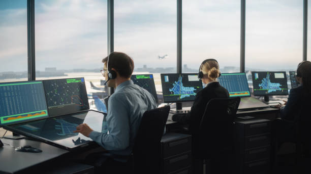 istock Diverse Air Traffic Control Team Working in a Modern Airport Tower. Office Room is Full of Desktop Computer Displays with Navigation Screens, Airplane Flight Radar Data for Controllers. 1319258416