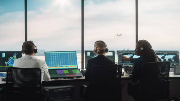 istock Diverse Air Traffic Control Team Working in a Modern Airport Tower. Office Room is Full of Desktop Computer Displays with Navigation Screens, Airplane Departure and Arrival Data for Controllers. 1319258426