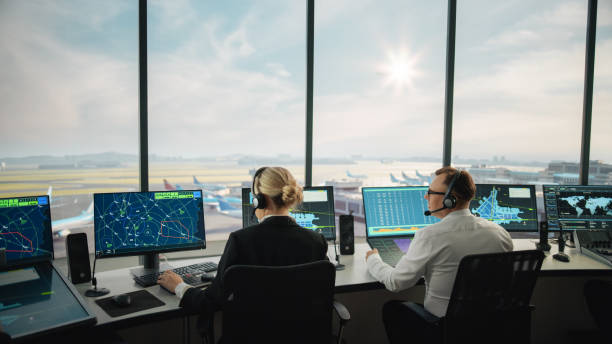 istock Diverse Air Traffic Control Team Working in a Modern Airport Tower. Office Room is Full of Desktop Computer Displays with Navigation Screens, Airplane Departure and Arrival Data for Controllers. 1319258438