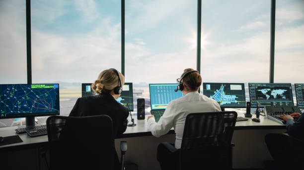 Diverse Air Traffic Control Team Working in a Modern Airport Tower. Office Room is Full of Desktop Computer Displays with Navigation Screens, Airplane Flight Radar Data for Controllers. equipo diverso de control de tráfico aéreo trabajando en una torre moderna del aeropuerto. la sala de oficinas está llena de pantallas de computadoras de escritorio con pantallas de navegación, datos de radar de vuelo de avión para controladores.