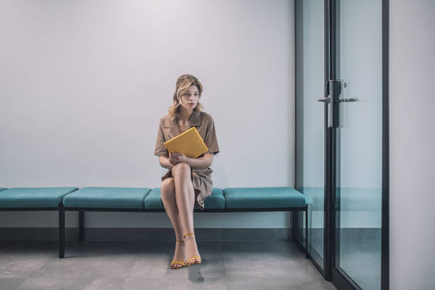 istock Sad woman with documents sitting in office corridor 1319259673