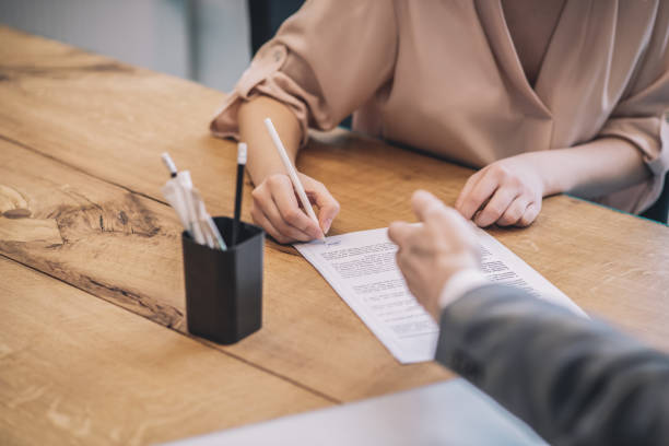 istock Woman hand signing document and male pointing 1319259674